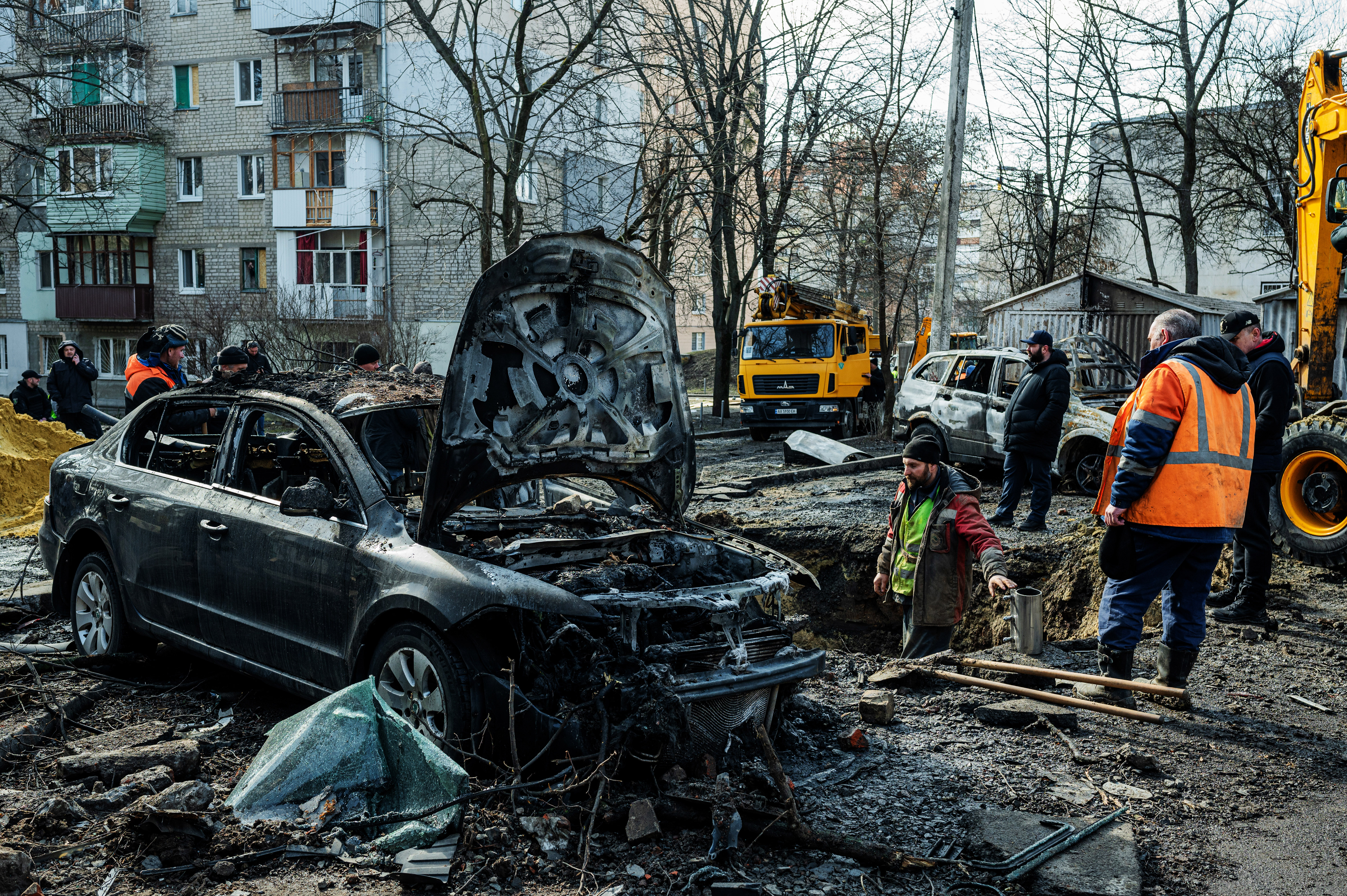 Municipal workers clear a residential courtyard after a nighttime airstrike. February 2024. ©Denis Vėjas