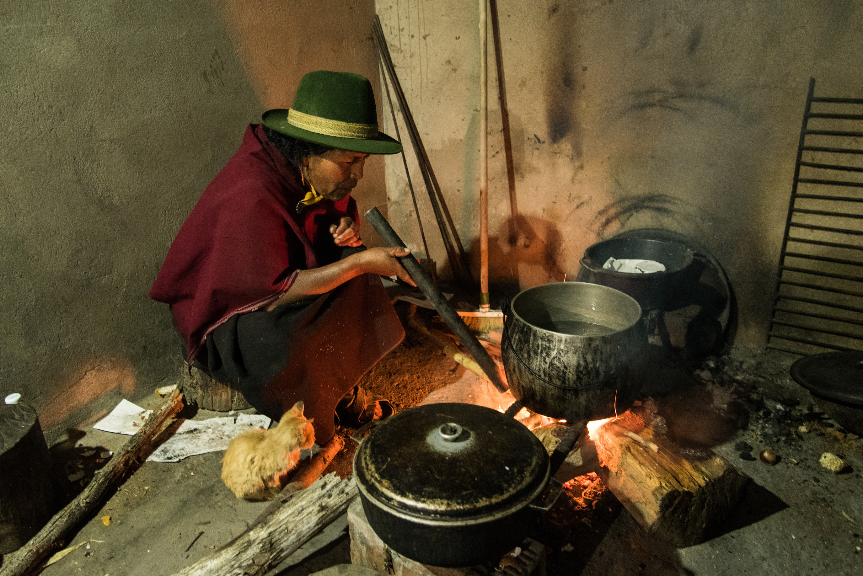 Martina Masaquiza Sailema kindles a fire in the kitchen to prepear late dinner.