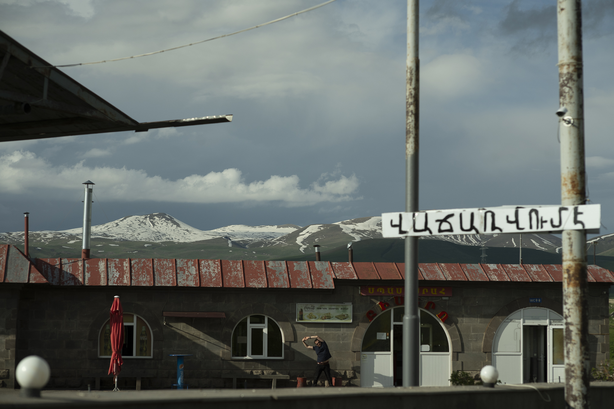 After a long drive, Stepan stretches at a petrol station. © Denis Vėjas