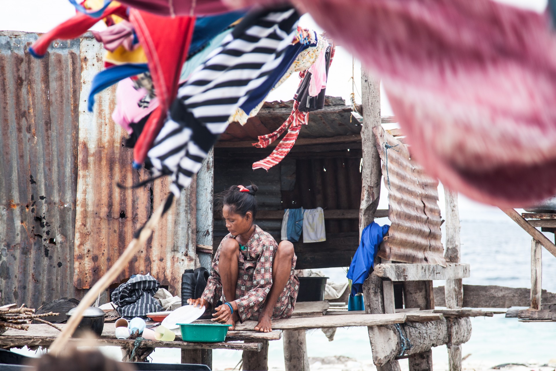 A Bajau Laut woman doing dishes in her cottage built on Sibuan Island, Malaysia.