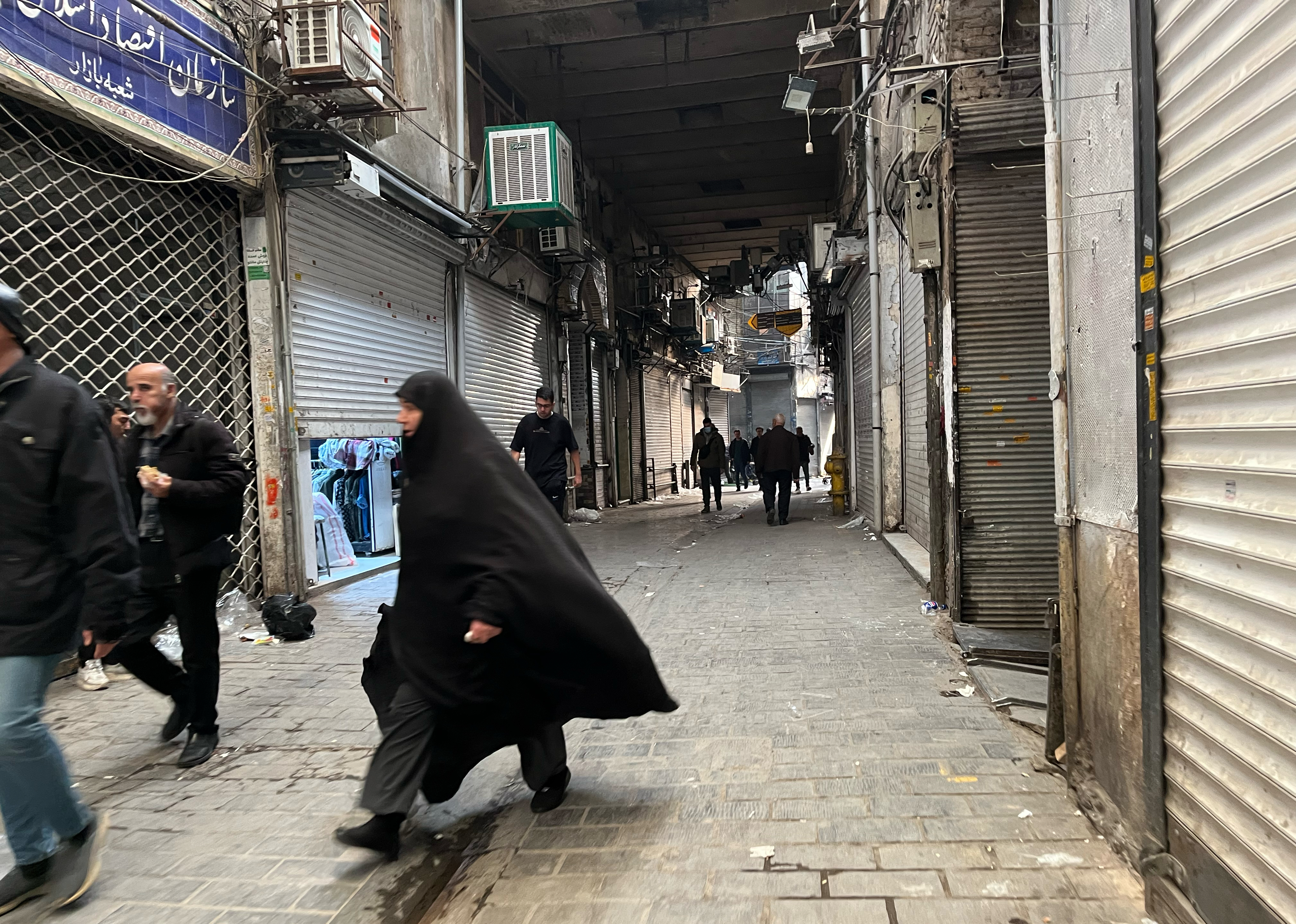 People walk as shops are closed during protests in Tehran's centuries-old main bazaar, Iran, Tuesday, January 6, 2026. ©AP Photo/Vahid Salemi