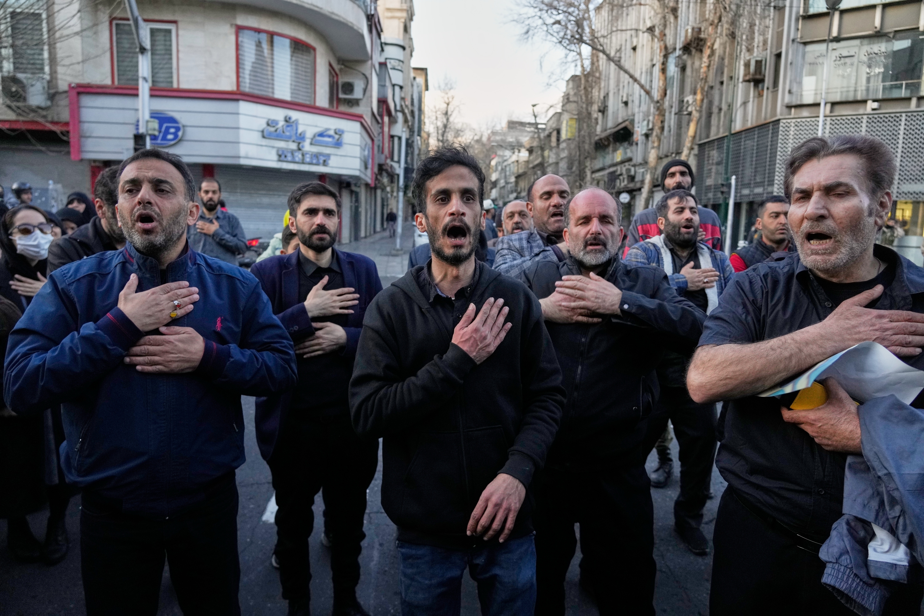 A group of men beat their chests as a sign of grief and mourning near the residency of the late Iranian Supreme Leader Ayatollah Ali Khamenei in Tehran, Iran, Sunday, March 1, 2026, in the aftermath of his confirmed death in U.S. and Israeli strikes. ©AP Photo/Vahid Salemi