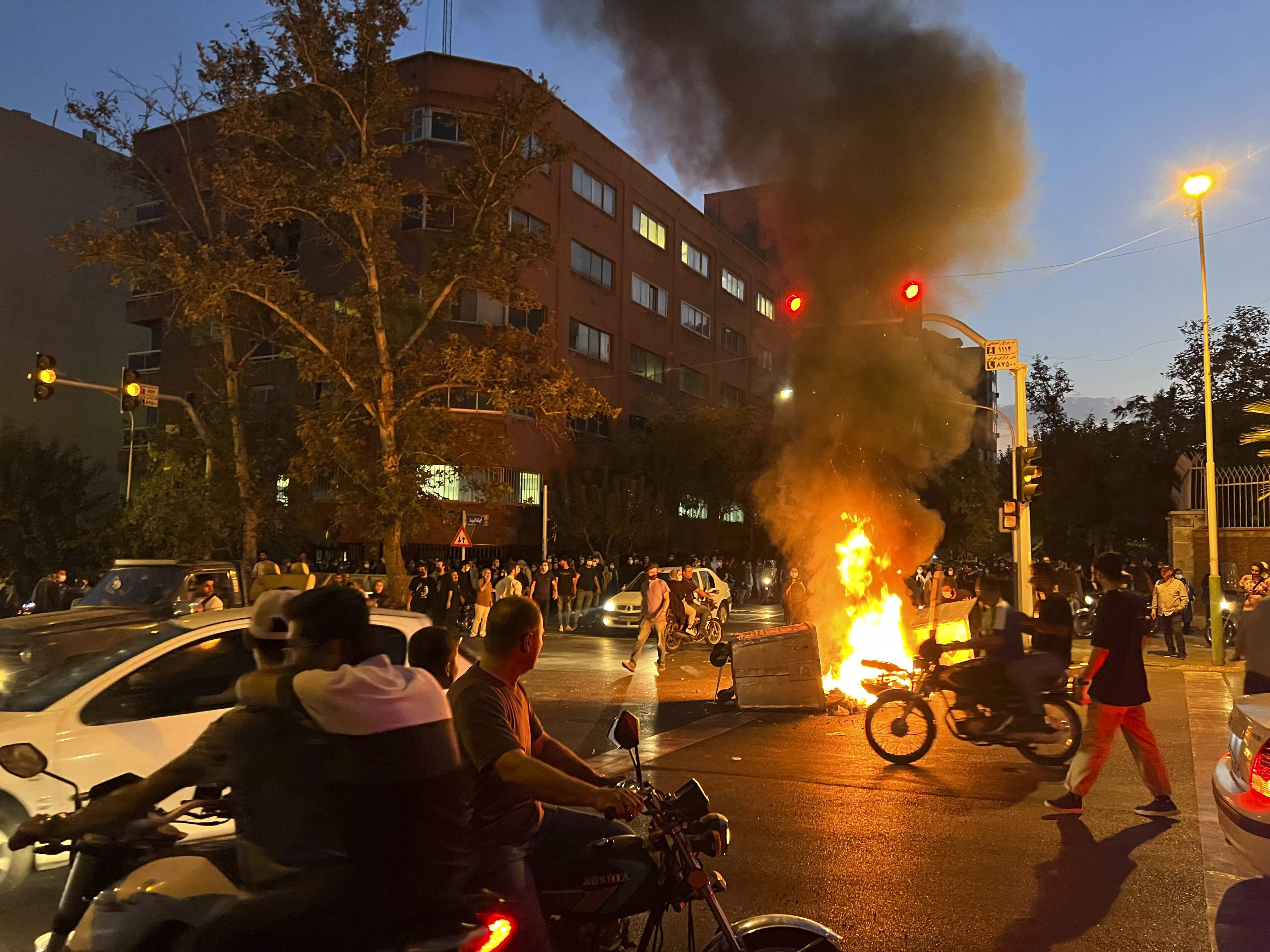 September 19, 2022. A police motorcycle and a trash bin are burning during a protest over the death of Mahsa Amini, a 22-year-old woman who had been detained by the nation's morality police, in downtown Tehran, Iran. ©AP Photo
