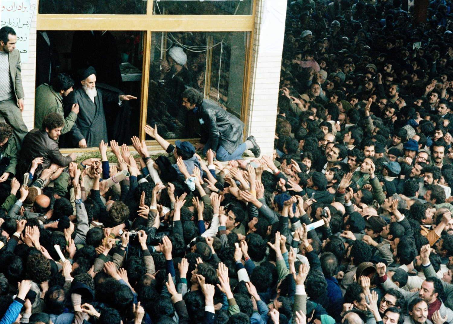 People jam into the schoolyard in Tehran to see the Ayatollah Ruhollah Khomeini, Khamenei's predecessor, who blesses the crowd, on February 4, 1979. ©AP Photo/Michel Lipchitz