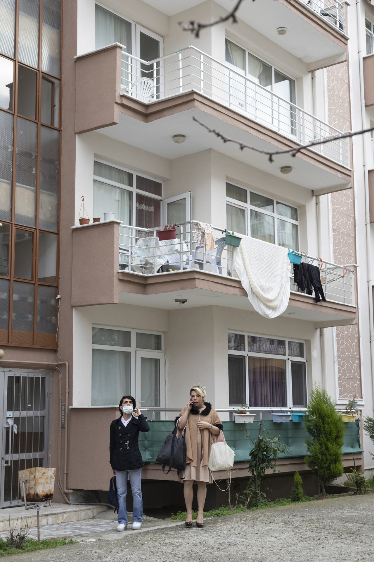 Maki and Baran are waiting for a taxi in front of their home.