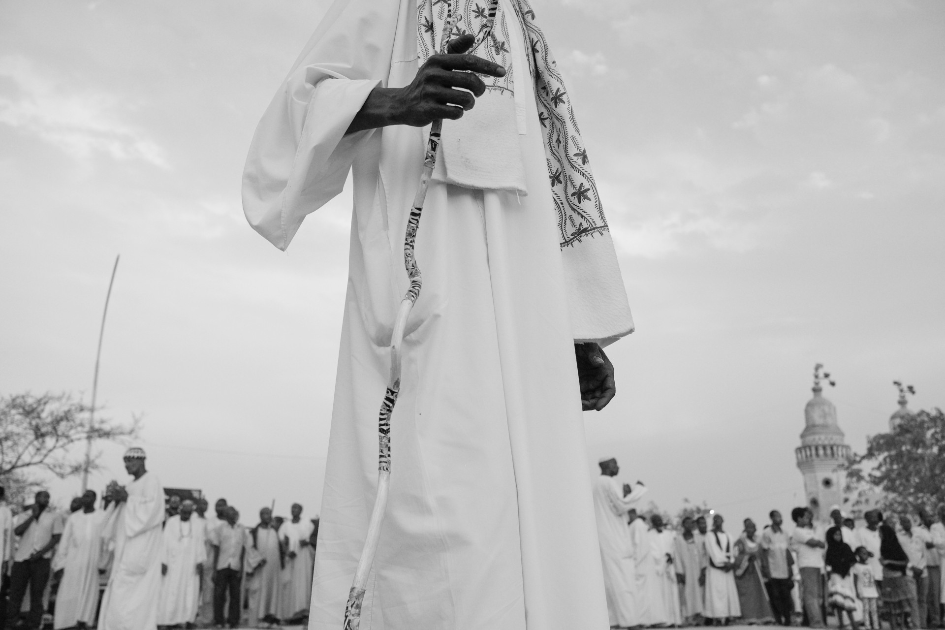Penktadieninio sufijų susirinkimo dalyvis rankoje laiko tradicinę lazdą. Sufijai tiki, kad Mohamedas ir kiti islamo pranašai viešumoje niekada nesirodydavo be ginklo ar lazdos, o islamiškų taisyklių rinkinyje Sunnah (iš arabų kalbos – Pranašo įpročiai) sakoma, kad kiekvienas save gerbiantis musulmonas turėtų su savimi nešioti lazdą. Metams bėgant, lazdos nešiojimo tradicija plačiajame musulmonų pasaulyje išnyko, tačiau sufijai iki šių dienų su savo lazdomis nesiskiria. Chartumas, Sudanas, 2017 m. Iš fotoistorijos „Sudano sufijai: iš reiklios sielos į sielą ramybėje“. ©Mykolas Juodelė