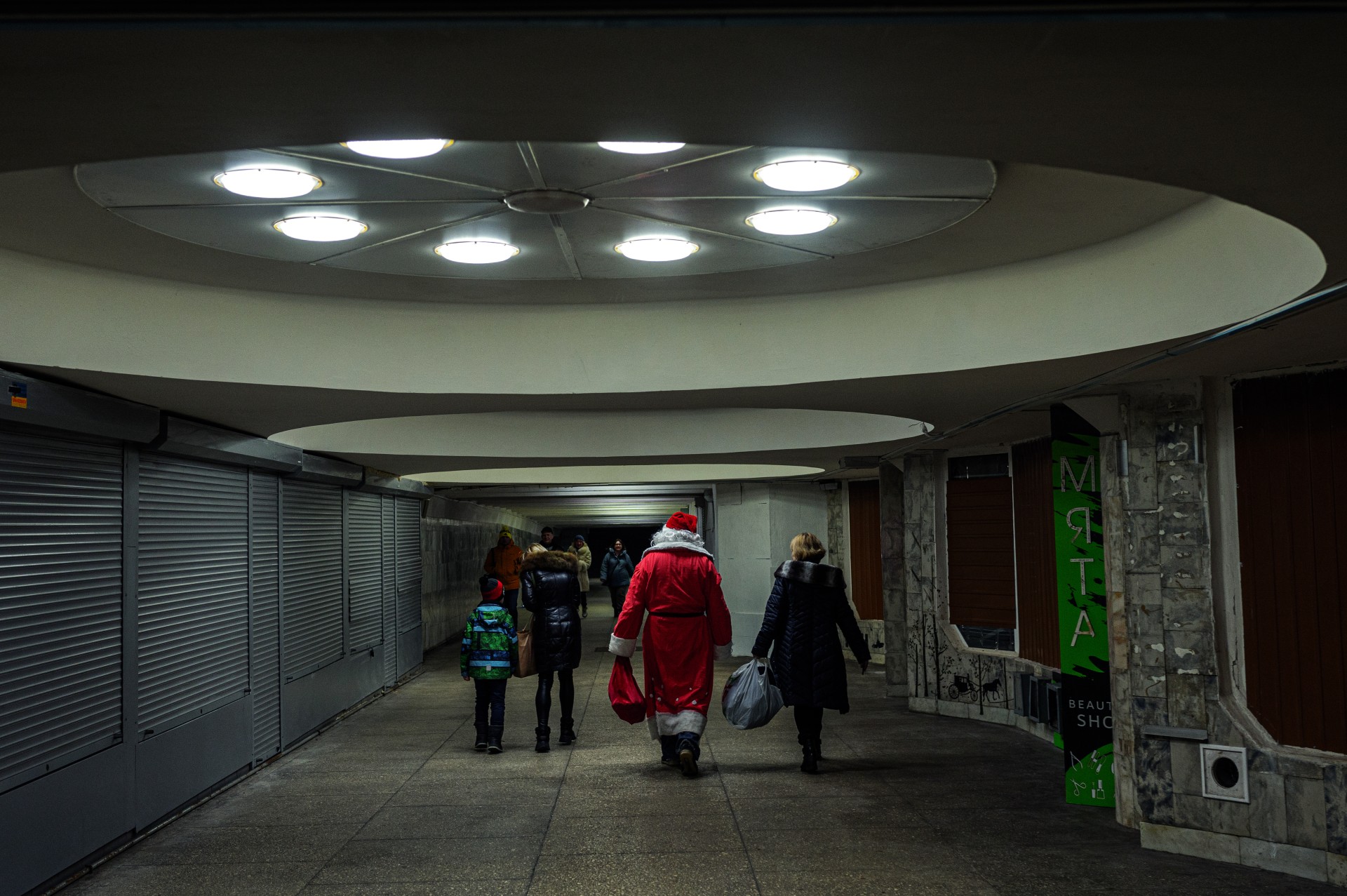 2024-ųjų Naujųjų metų išvakarėse Kalėdų Senelis dalija dovanas vaikams požeminėse metro perėjose. ©Denis Vėjas