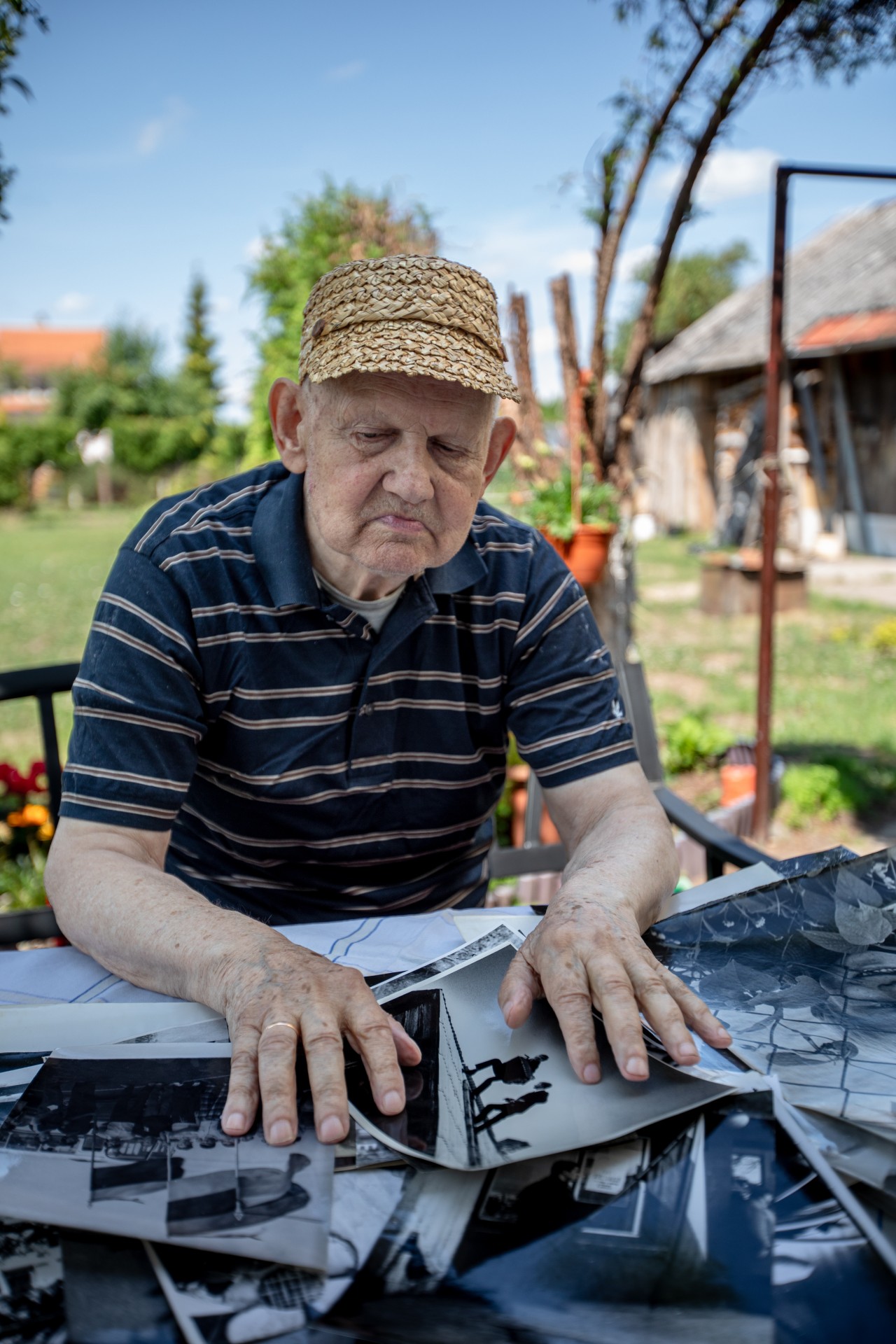 Benjaminas apžiūri savo darytas nuotraukas, padengusias visą stalą. ©Mindaugas Černeckas