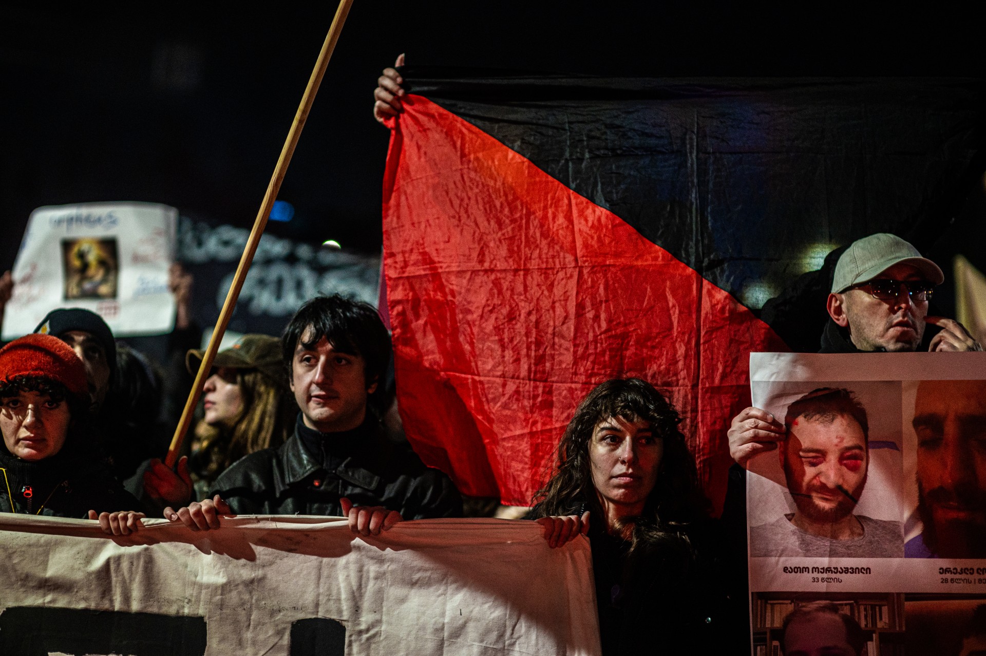 Reiverių ir naktinių klubų bendruomenės eisenoje protestuotojai neša policijos sumuštų žmonių nuotraukas. ©Denis Vėjas