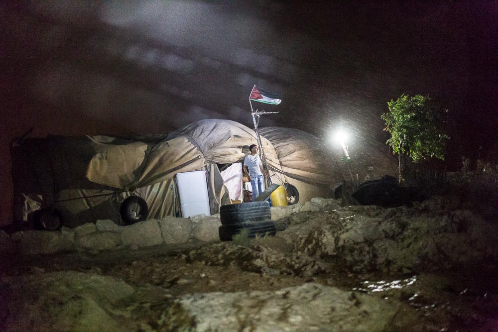 Vaikinas stebi staiga kilusią audrą Susijos gyvenvietėje, Vakarų krante. Dėl itin brangaus ir limituoto, Izraelio kontroliuojamo vandens tiekimo Palestinoje, daugeliui smulkių vietos ūkininkų, lietus yra pagrindinis vandens gavimo šaltinis. ©Artūras Morozovas