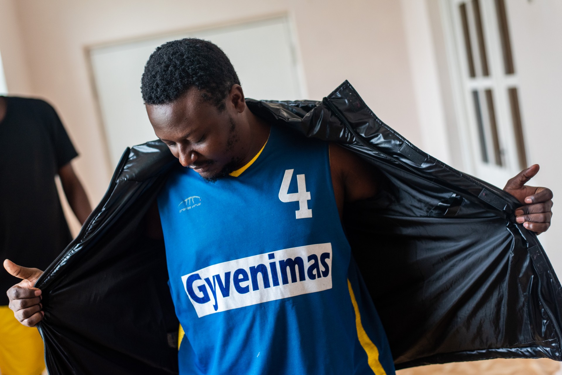 Joel iš Kamerūno rodo marškinėlius, kuriuos rado tarp žmonių migrantams paaukotų drabužių. Vydenių mokykloje, Varėnos rajone buvo apgyvendinta virš 160 migrantų iš Afrikos šalių. ©Berta Tilmantaitė