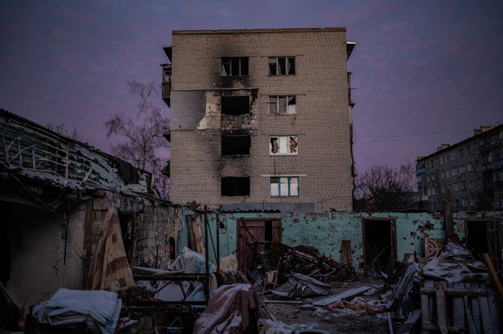 Kiemas Iziume, kuriame tarp suniokotų namų ir jų nuolaužų stovi penkios sudegusios mašinos. Namo rūsyje slepiasi žmonės. ©Denis Vėjas