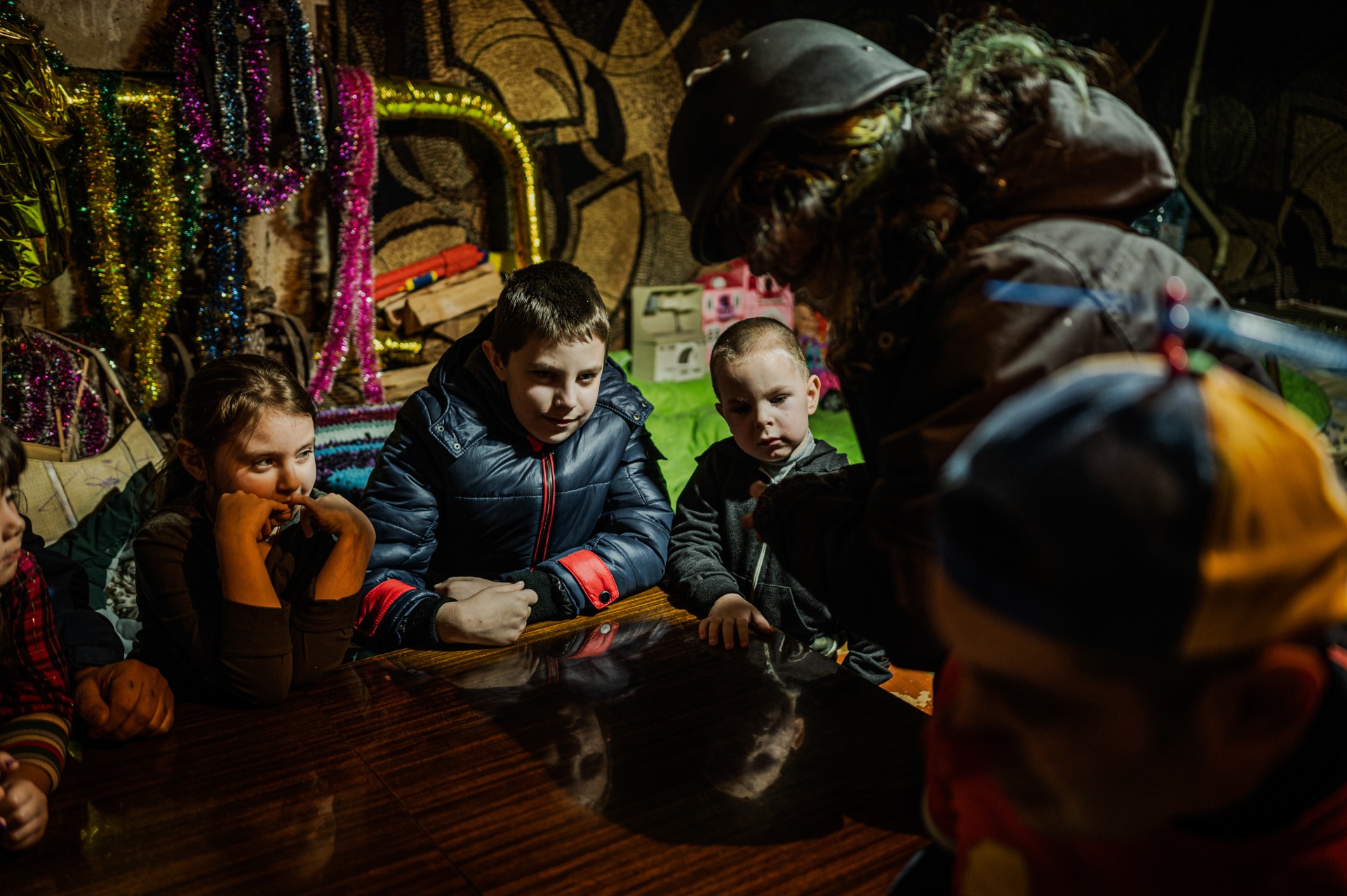 Visai šalia netikėtai pasigirsta garsus sprogimas. Norėdami nukreipti vaikų dėmesį, Marco ir Malika pradeda mokyti juos kortų žaidimo. ©Denis Vėjas