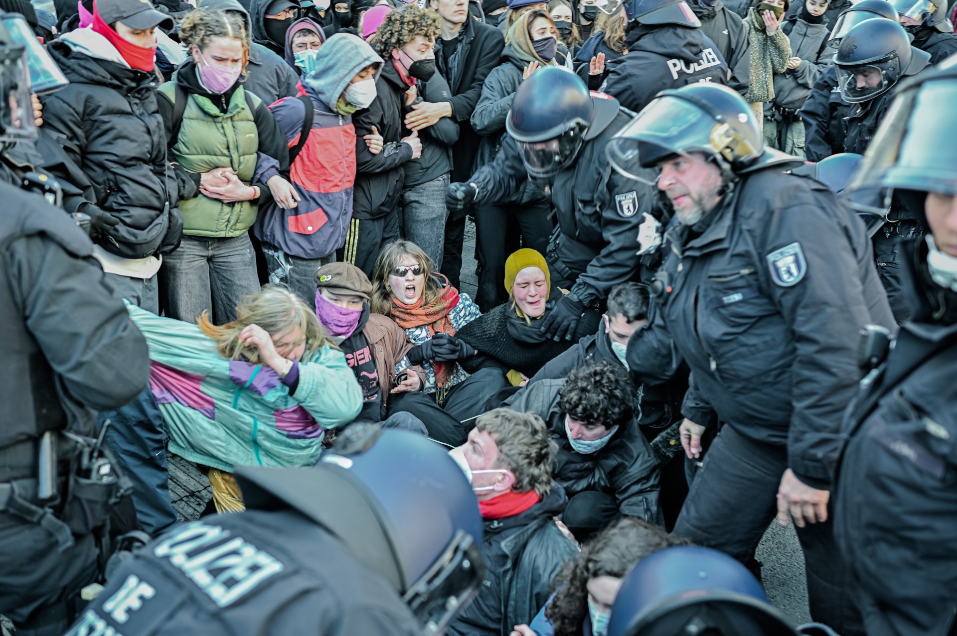 Kai kurioms kontrprotestuotojų grupėms pavykdavo prasiskverbti pro policijos kordonus. Jie susėsdavo ant žemės, susikibę už alkūnių, taip sudarydami gyvas barikadas ultradešiniųjų kelyje. Policija atplėšdavo žmones iš grandinių ir sulaikydavo. ©Denis Vėjas