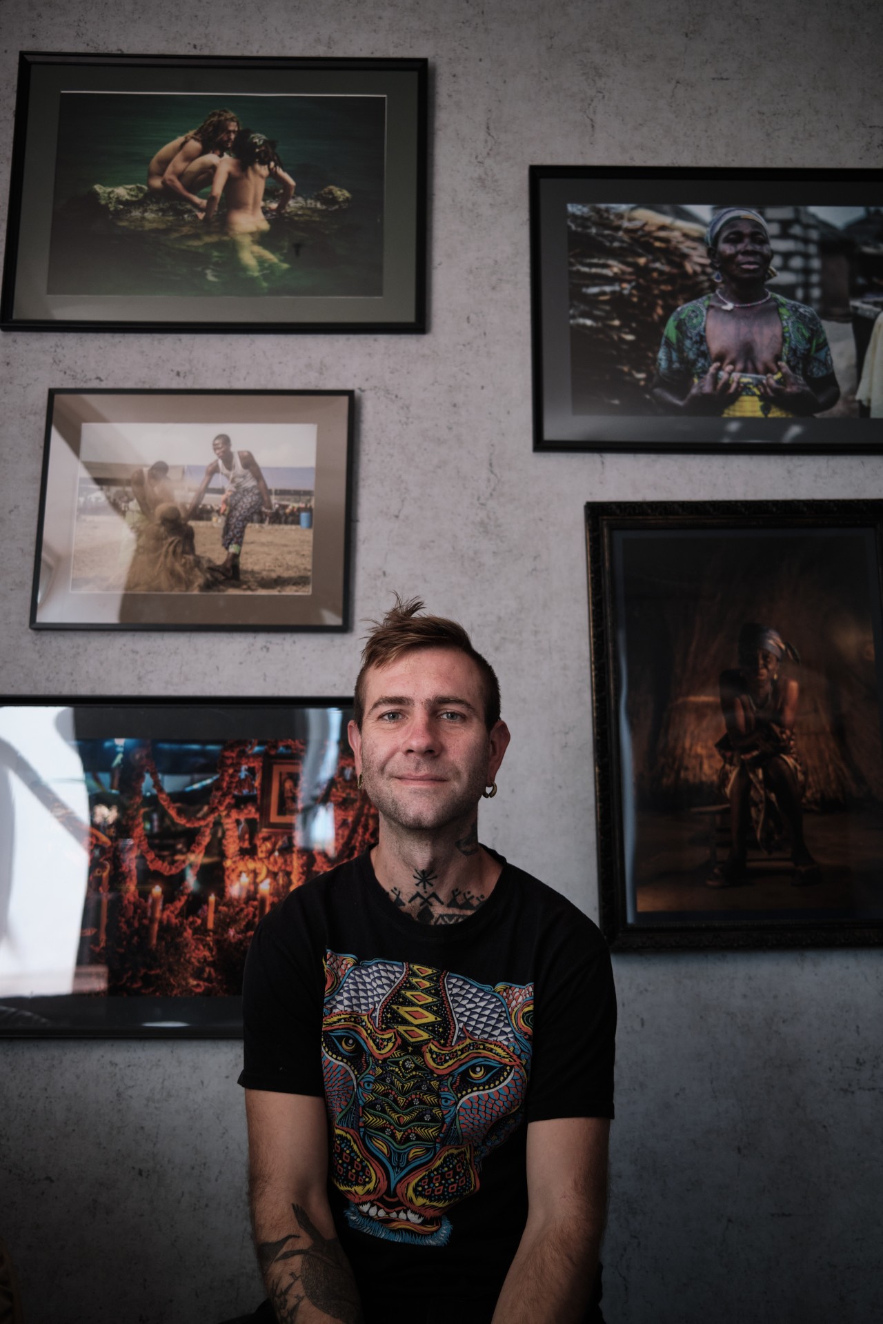 Denis prie savo fotografijų iškabintų namuose. ©Karolis Pilypas Liutkevičius