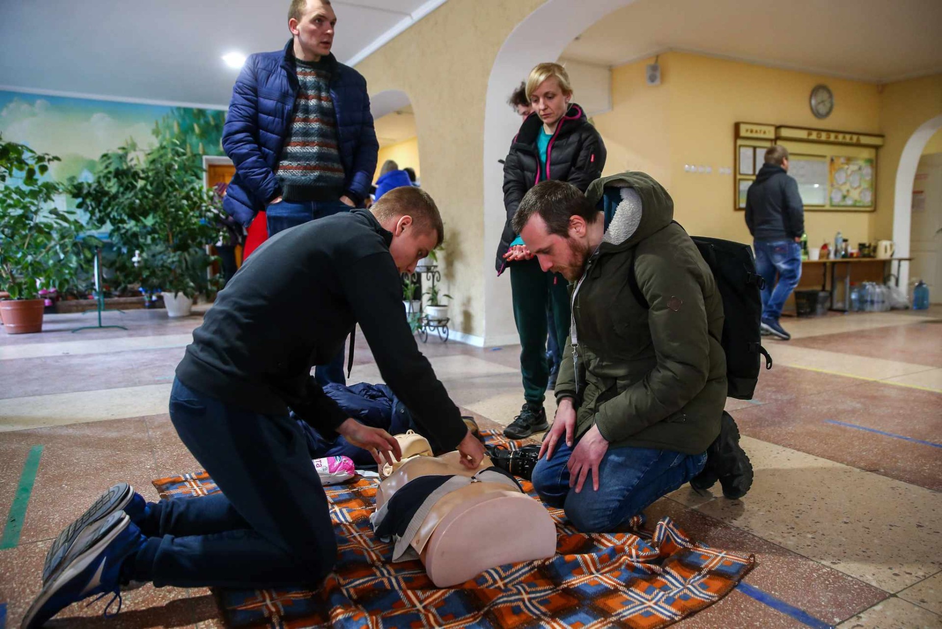 Fotožurnalistas Benas Gerdžiūnas stebi taktinės medicinos mokymus užsirašiusiems į gynybą pirmomis karo dienomis Žytomyre. ©Slava Ratysnkyi