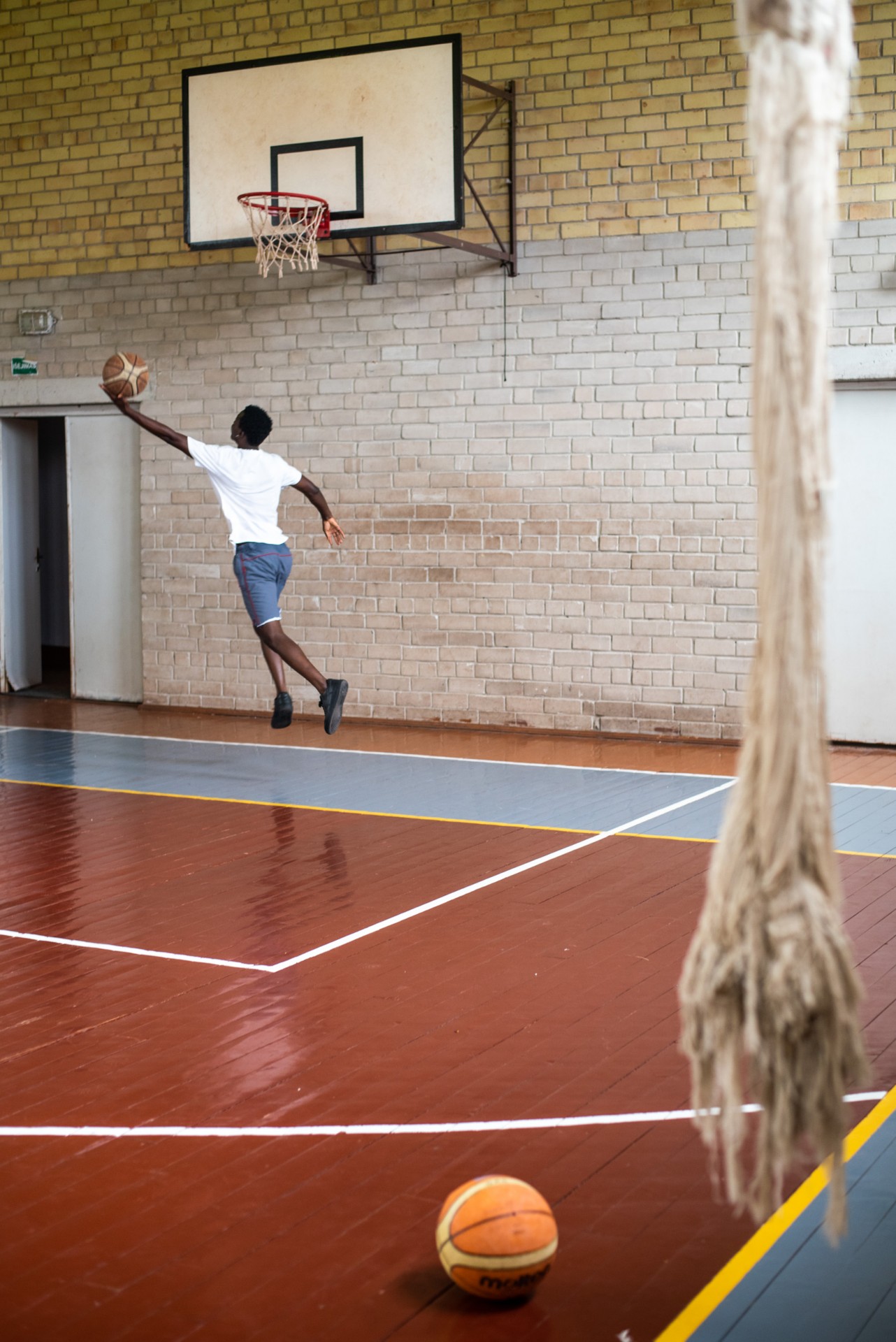 Vaikinai žaidžia krepšinį sporto salėje Vydeniuose, mokykloje, kur buvo įrengta laikina migrantų stovykla. 2021-ųjų rugpjūtis ©Berta Tilmantaitė