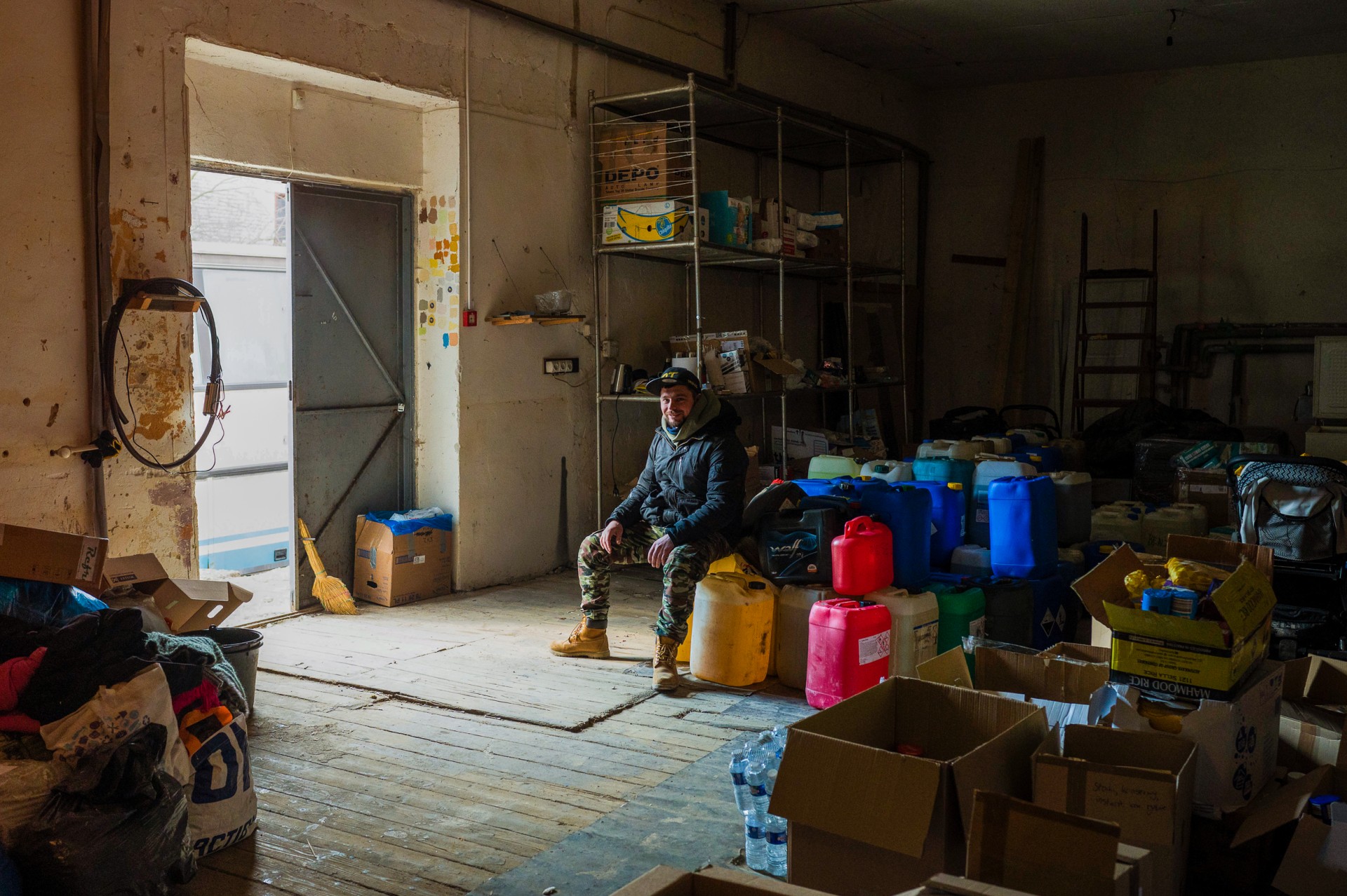 Gediminas Ivanauskas – profesionalus lenktynininkas, nufotografuotas humanitarinės pagalbos išskirstymo sandėlyje. Sportininkas paliko savo verslą Lietuvoje ir kartu su vietiniais Ukrainos savanoriais užsiima humanitarinės pagalbos koordinavimu ir žmonių išvežimu iš karštų Ukrainos taškų.