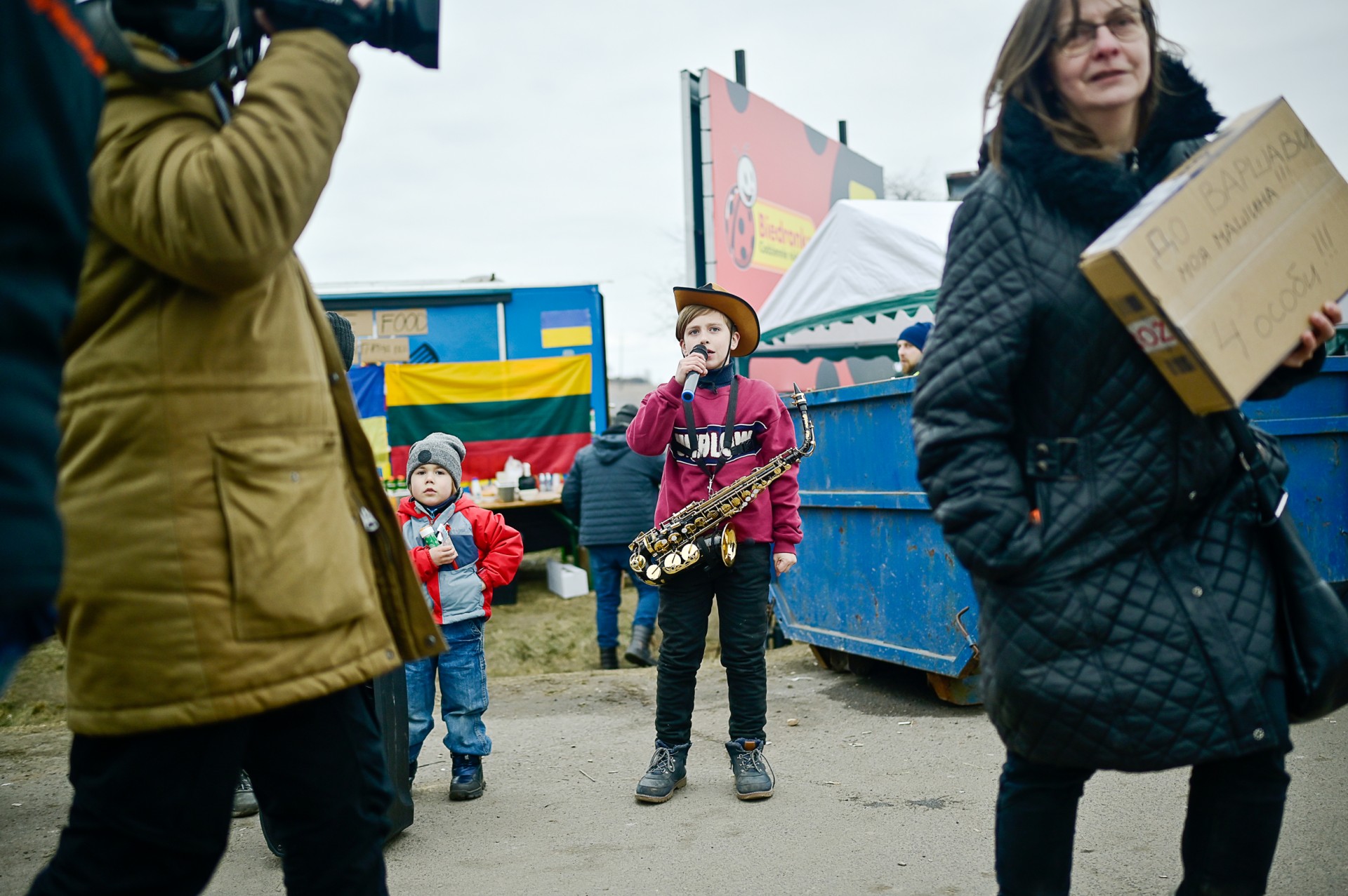 Ukrainietis berniukas groja saksofonų, kviesdamas praeivius sekti jo YouTube kanalą.