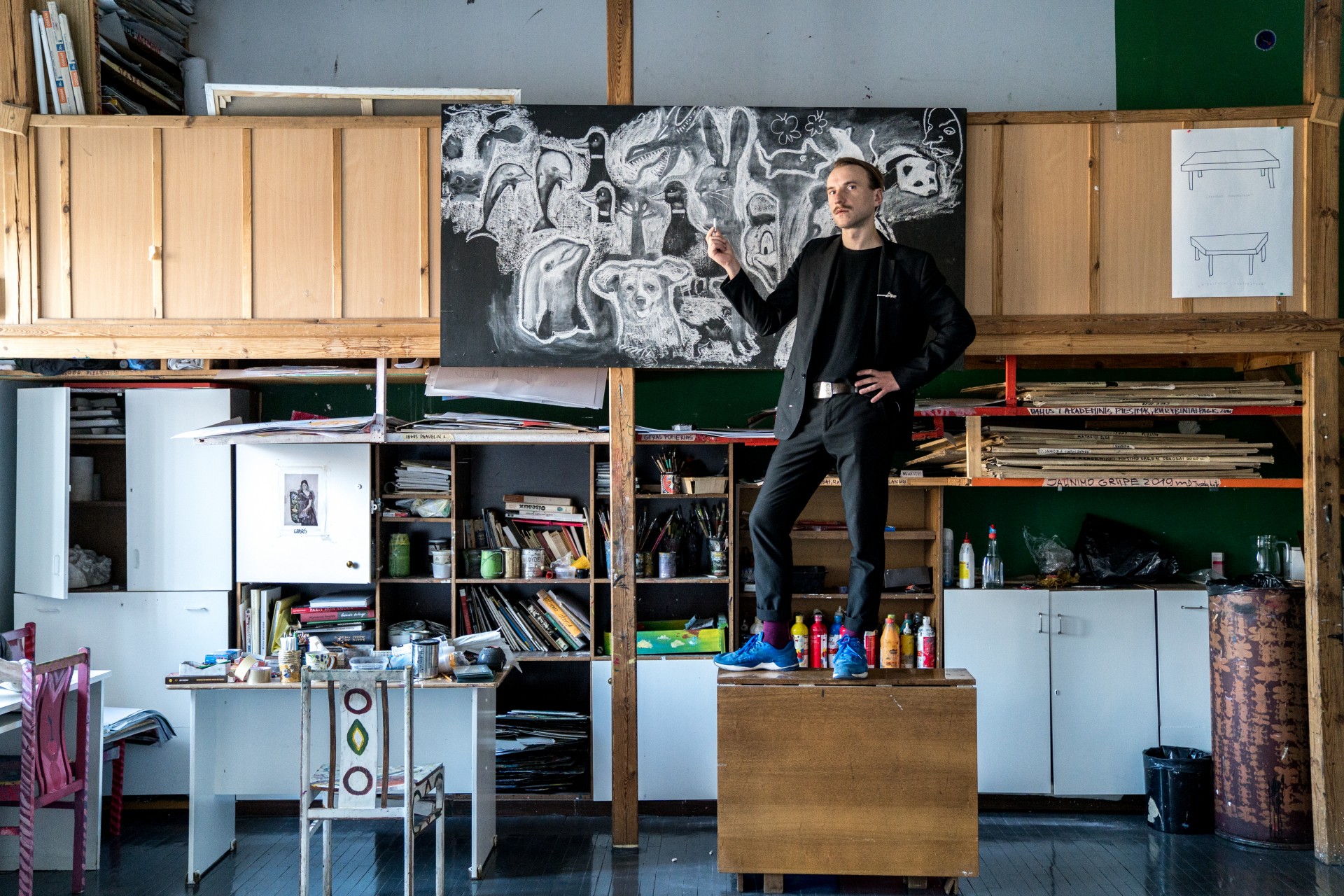 Dailininkas Algimantas Černiauskas studijoje Vilniuje. Dirbant Pabradėje jam užteko kreida nupiešti vieną paukštį – vaikai prisijungė savais piešiniais. Jį stebino kontrastas tarp laisvos vaikų energijos ir fakto, kad jie gyvena greta spygliuota viela aptvertos teritorijos ©Mindaugas Drigotas