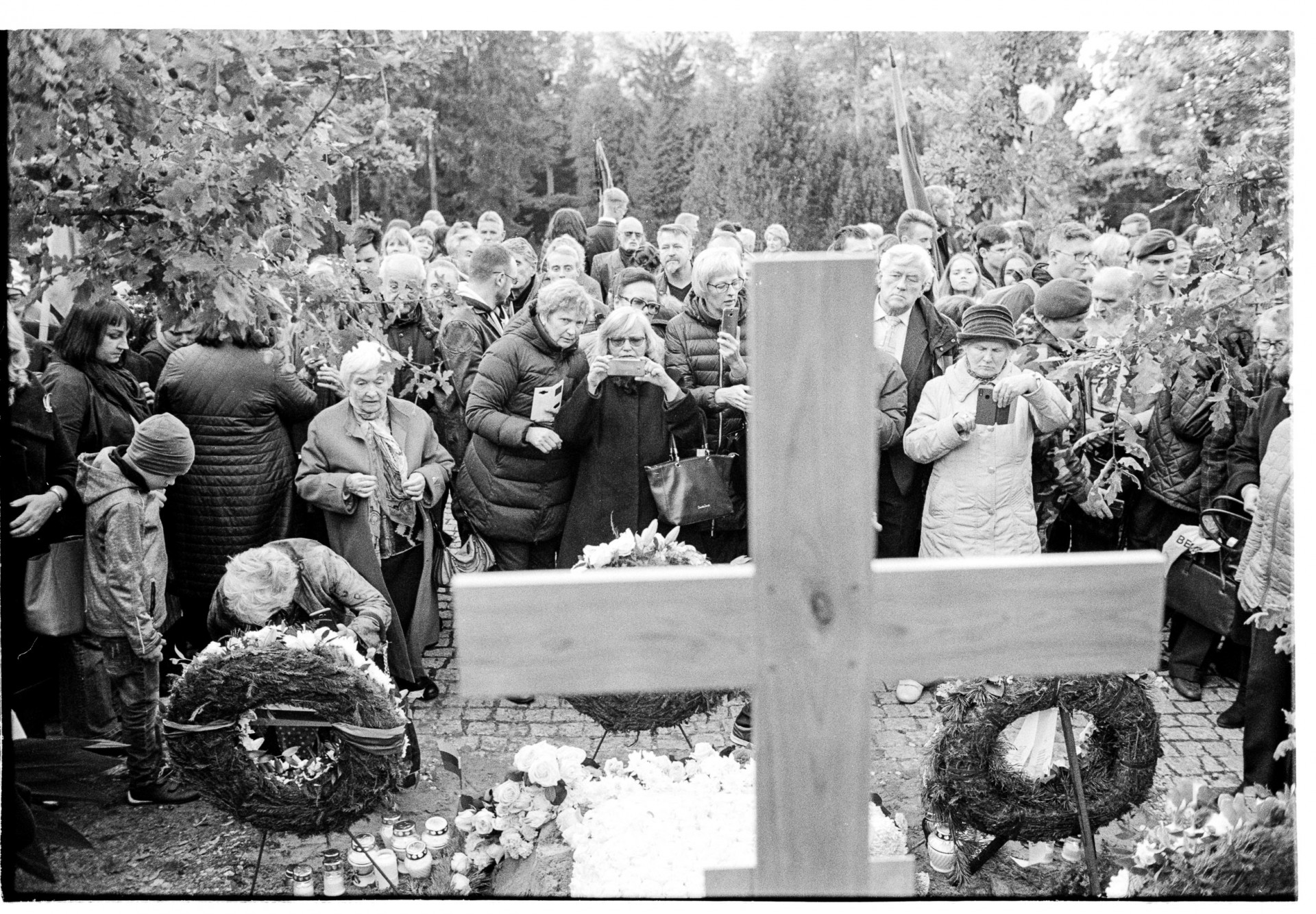 Žmonės išreiškia pagarbą prie palaidoto partizano kapo.