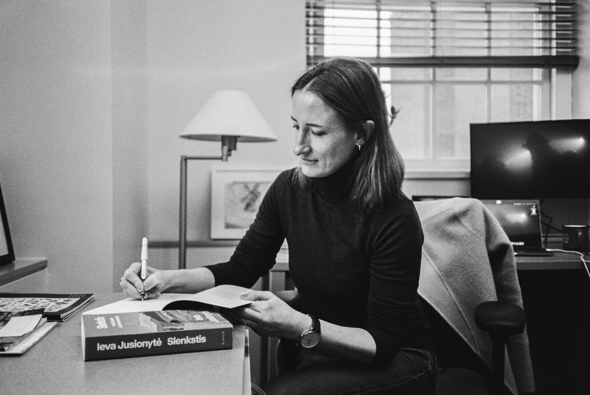 Ieva Jusionytė pasirašo originalų savo 2018 m. knygos „Threshold“ leidimą savo darbo kabinete Harvarde.