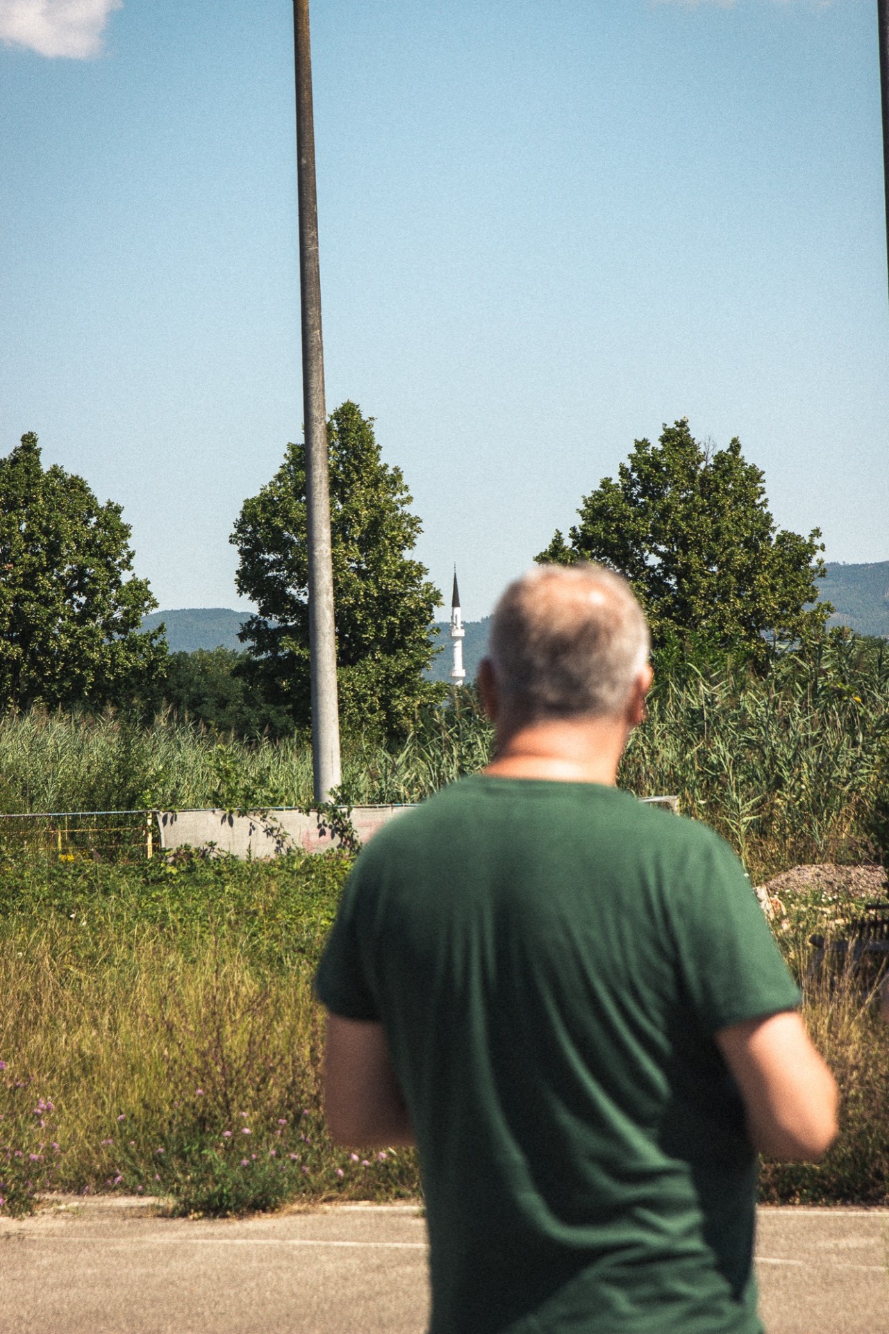 Stadione šalia Trnopolje koncentracijos stovyklos Satko Mujagić žvelgia į minaretą, iš kurio, anot vietinių pasakojimų, per karą snaiperis nušovė šioje aikštelėje stovėjusį koncentracijos stovyklos kalinį. ©Remigijus Paulauskas