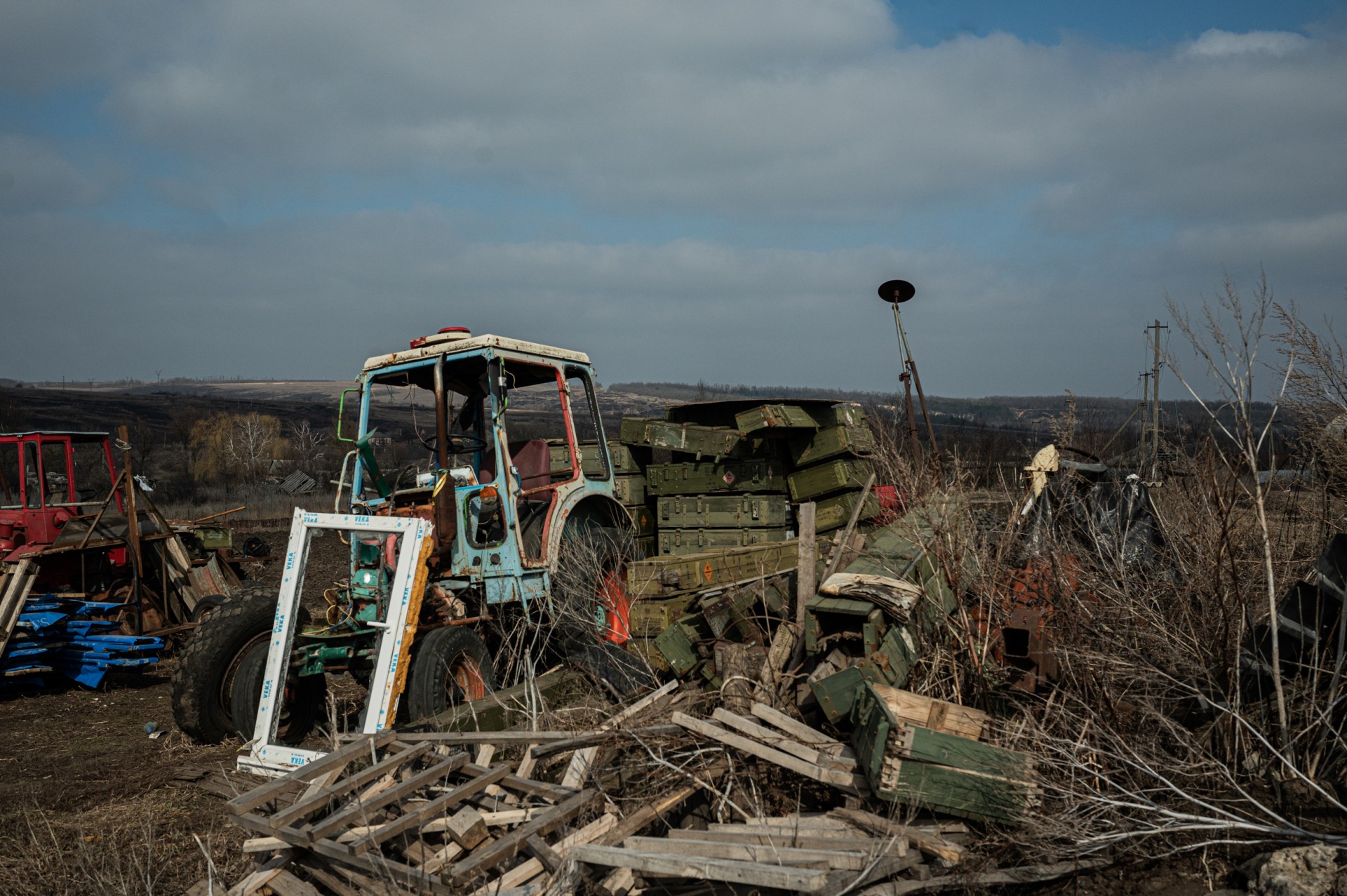 Apgadintas traktorius, nuolaužos ir rusų karių paliktos amunicijos dežės Kornyičių namų kieme. ©Denis Vėjas