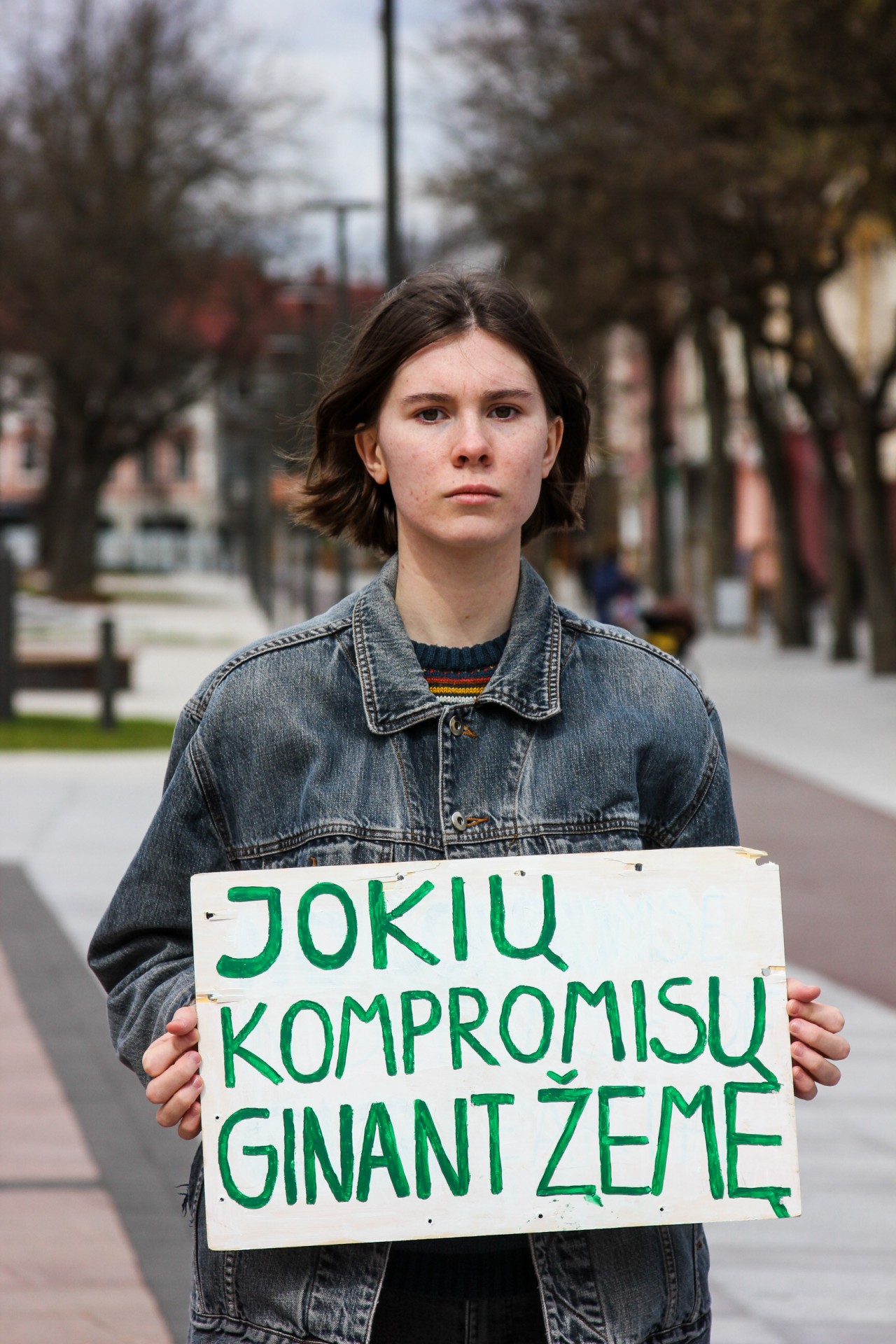 Viltė Zaveckaitė su plakatu prie Panevėžio miesto savivaldybės. ©Austėja Zaveckaitė
