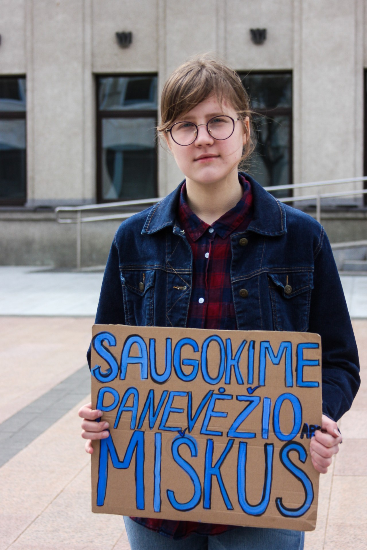 Ugnė Misevičiūtė su plakatu prie Panevėžio miesto savivaldybės. ©Austėja Zaveckaitė