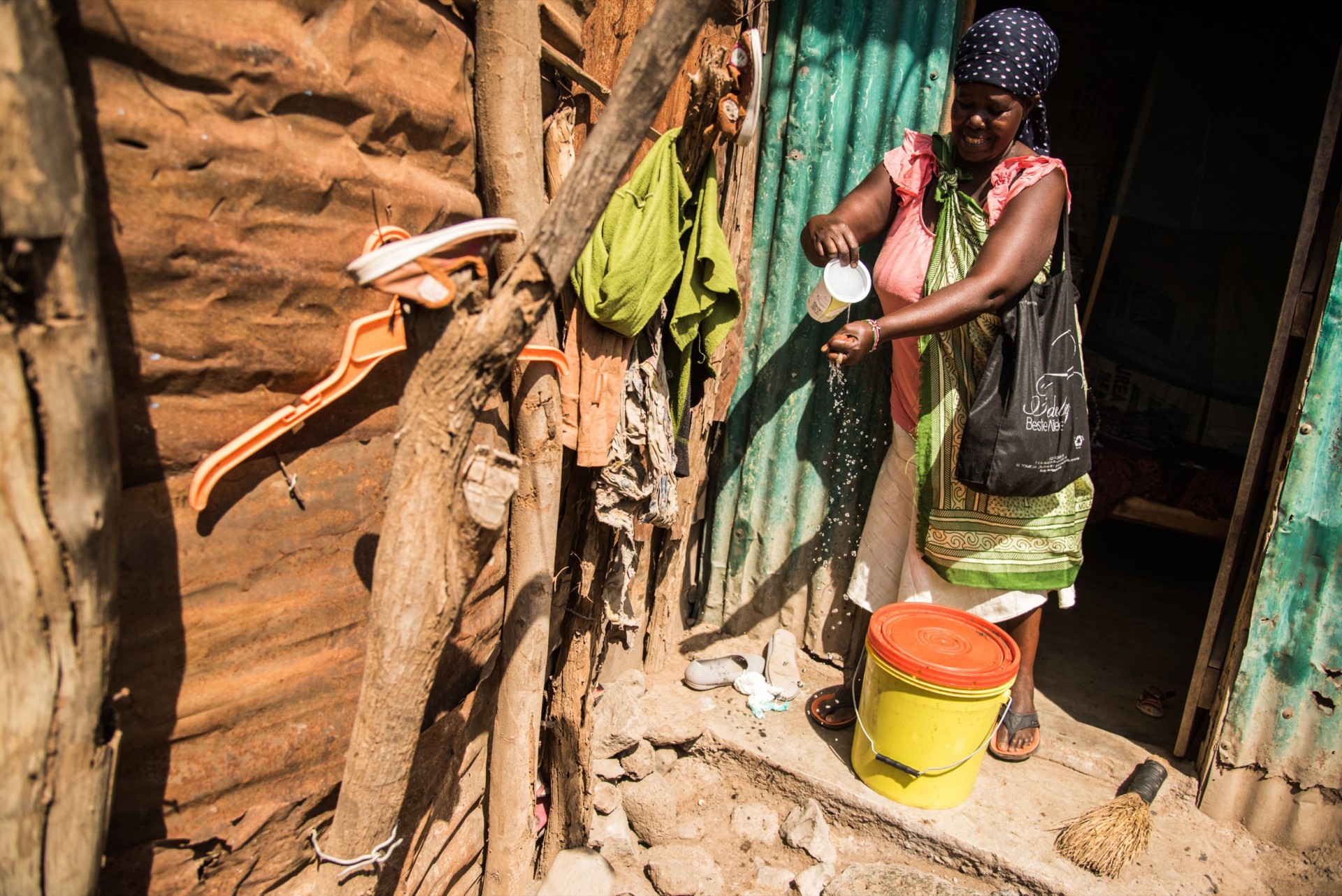 Prieš keliaudama į turgų su kibiru medaus, Agnes Cheptepkeny plaunasi rankas savo namelio tarpduryje.