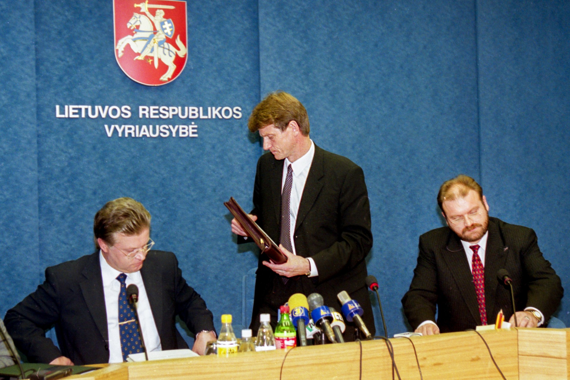 Diena po premjero Rolando Pakso viešo atsisakymo pasirašyti sutartį. Ministrų kabinetas, nepritardamas premjerui, balsuoja už sutarties pasirašymą (11 ministrų už, 3 prieš, 1 susilaikė). Spaudos konferencijoje ūkio ministras Eugenijus Maldeikis ir finansų ministras Jonas Lionginas, nepritardami Vyriausybės daugumai, paskelbia, kad atsistatydina iš pareigų. Vyriausybė, 1999 m. spalio 19 d.