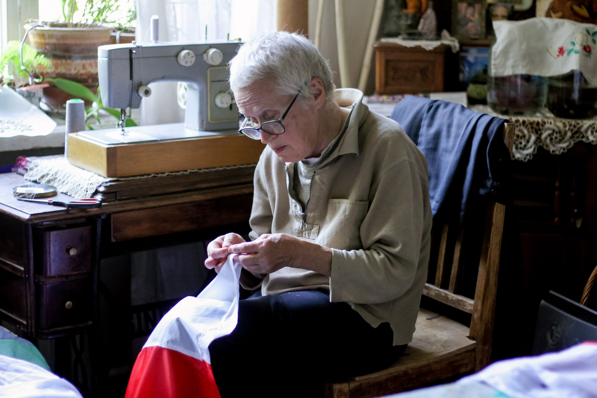 Нина Багинская у себя дома шьет бело-красный-белый флаг Беларуси ©Marta Klinava